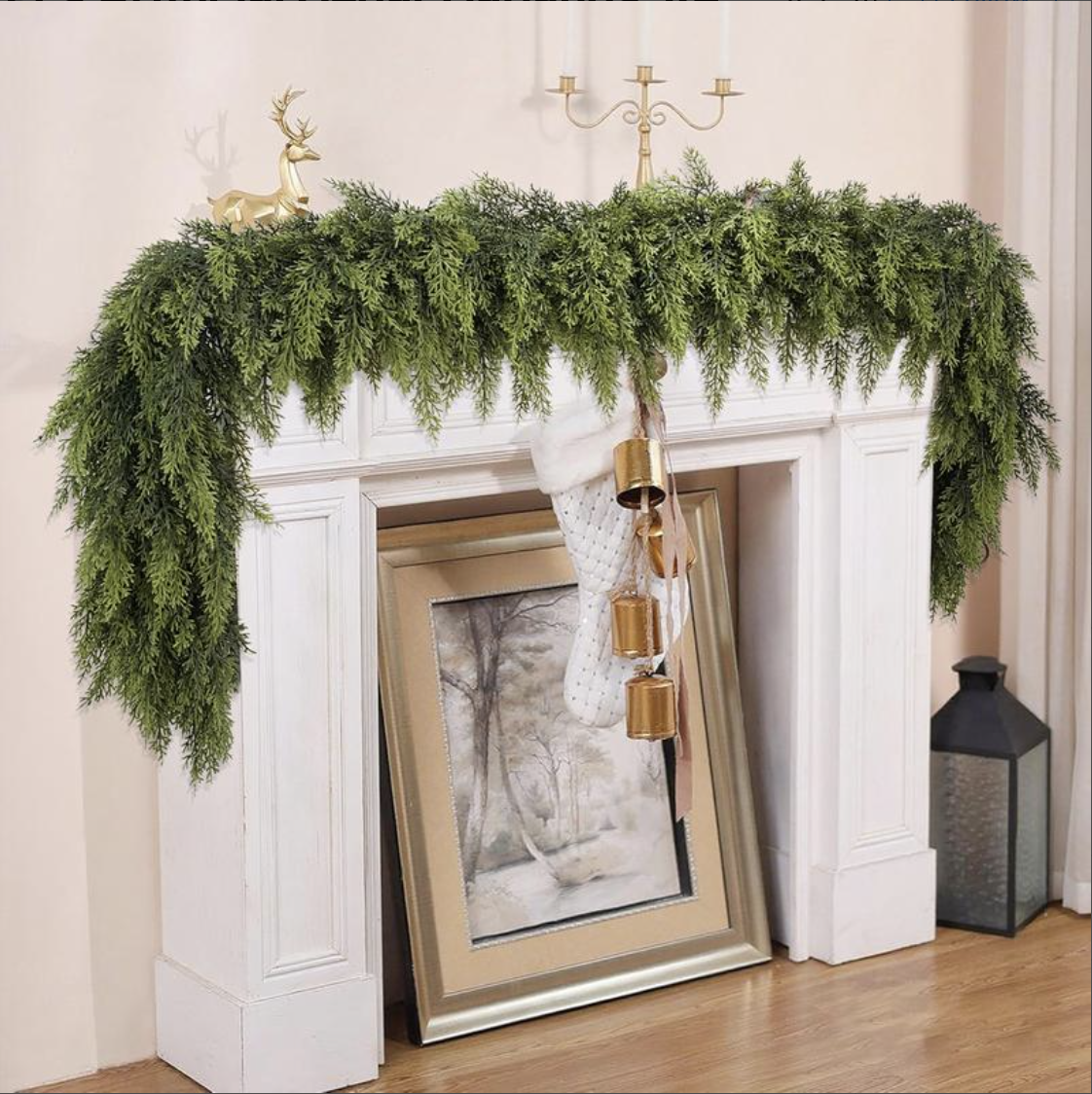 Cedar garland draped across a white mantel with gold bells